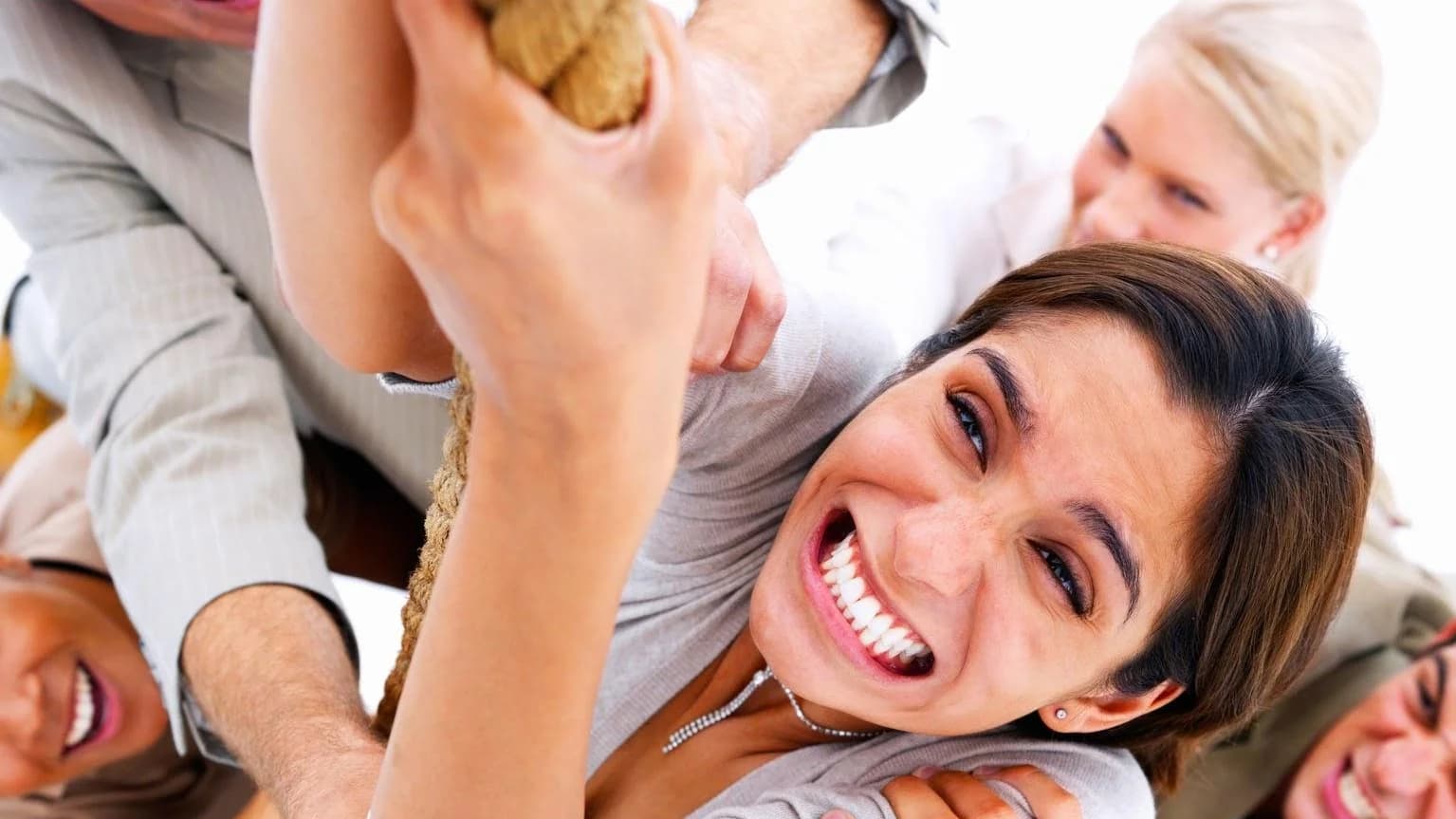 Grupo de pessoas sorrindo e erguendo os braços juntas, em clima de equipe